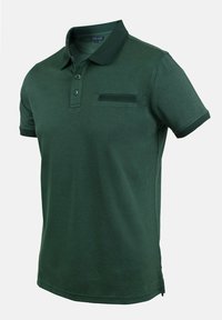 Polo de color verde oscuro confeccionado en una tela suave, con un cuello de dos botones, detalle de bolsillo bordado y bordes de color contrastante en el cuello y las mangas.