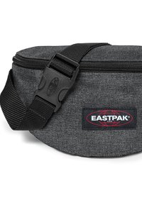 Grå stof bæltetaske med lynlås, justerbar rem og fremtrædende Eastpak logo-patch. Rundet form og glat tekstur.