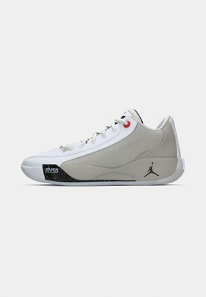 Biele a šedé nízkopodrážkové basketbalové topánky s čiernym logom Jumpman, červeným očkom na šnúrky a čiernym textom "Air Zoom" na podrážke pri špičke.