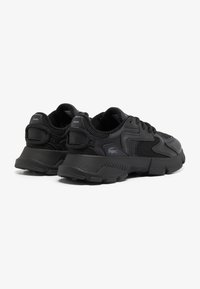 Las zapatillas deportivas negras presentan una parte superior de malla y sintético con acentos texturizados, un collar acolchado y una suela de goma gruesa para mayor soporte.