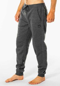 Grå bomulds sweatpants med elastisk talje, snoretræk og sidelommer. Har et lille mærke på forsiden.
