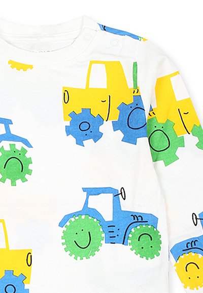 Camicia bianca a maniche lunghe con trattori gialli e ingranaggi verdi e blu con faccine sorridenti in un motivo giocoso. Chiusura a scatto sulla spalla.