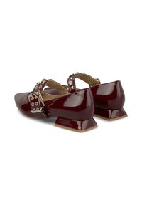 Scarpe in pelle verniciata bordeaux con punta appuntita, doppia fascia con fibbia e tacco basso e quadrato. Presentano hardware dorato e dettagli testurizzati.