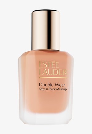 Estee Lauder Double Wear -meikkivoide kirkkaassa lasipullossa, pyöristetyt reunat, vaalea persikan sävy, kullanvärinen korkki, musta tekstilaatta.