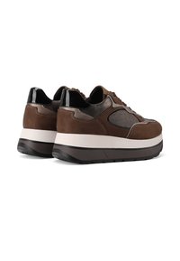 Un paio di sneaker platform marroni con accenti neri, intersuole bianche e pannelli testurizzati, mostrati da angolazioni posteriori e laterali.
