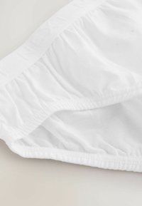 Caleçons en coton blanc avec une bande élastique douce, présentant des détails en tissu froncé, une texture lisse et un design à coupe classique.