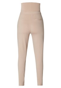 Hoge beige leggings met een elastische tailleband en een klein achterzakje aan de rechterkant, weergegeven vanuit de achterkant.