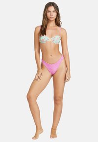 Bikini-set med en mintgrön blommönstrad topp med vriden framsida och justerbara rosa axelband; matchande rosa högskurna underdelar.