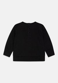 Svart langermet genser med rund hals, ribbestrikket nederkant og mansjetter, samt en knappåpning bak. Glatt, myk stofftekstur.