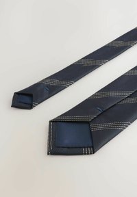 Marineblaue Seidenkrawatte mit diagonalen, beige gestickten Streifen, flach präsentiert mit sichtbaren Vorder- und Hinterenden auf einem hellen Hintergrund.
