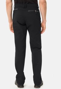 Pantaloni softshell neri a vestibilità slim, dotati di tasca posteriore con zip, tessuto elastico e dettagli rinforzati sulle ginocchia per una maggiore durata.