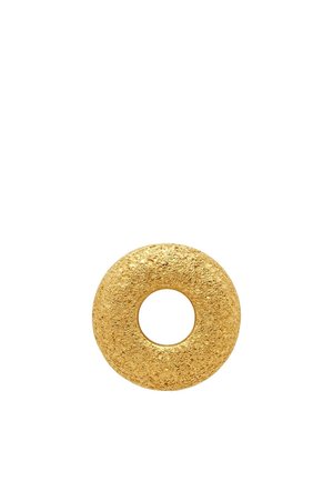 Objet rond texturé en métal doré en forme de beignet avec un centre creux sur fond blanc.