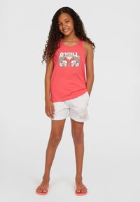 Korallenfarbenes Tanktop mit Blumenmuster, kombiniert mit hellgrauen Shorts mit Logo. Kindersandalen runden den lässigen Look ab.