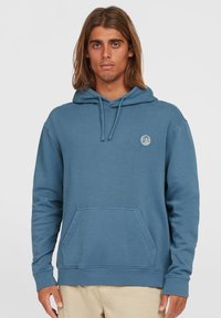 Blue cotton hoodie with a kangaroo pocket, adjustable drawstring hood, and small round logo on the chest. Smooth texture and relaxed fit.