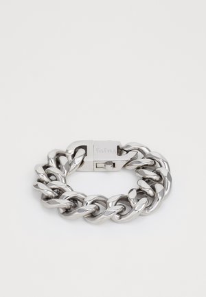 Bracelet en chaîne métallique argentée épaisse avec un fermoir rectangulaire gravé "fainz", reposant à plat sur un fond blanc.
