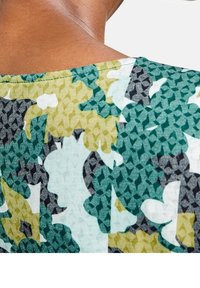 Tejido estampado que presenta tonos de azul verdoso, verde y beige. El diseño incluye formas abstractas y un acabado de punto texturizado.