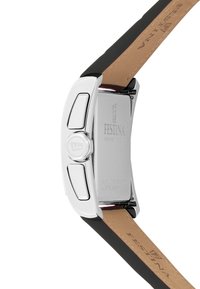 Festina-kello, jossa on hopean värinen ruostumaton teräskuori, musta kumihihna ja nahkaperusta. Varustettu erottuvalla kruunulla ja kaiverretulla logolla.