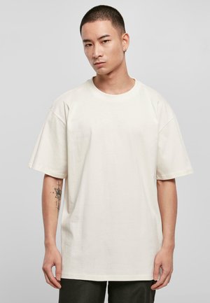 Ensfarvet cremefarvet t-shirt, kortærmet, rund halsudskæring, med subtile broderede detaljer på fronten, fremstillet af bomuldsstof.
