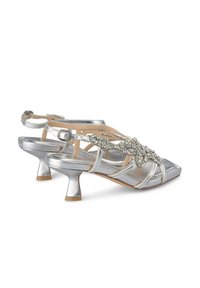 Zilveren sandalen met hakken en een metallic afwerking, voorzien van decoratieve strass accenten, een vierkante neus en een middenhoog blokhak.