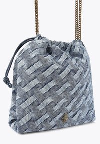 Tkaná modrá denimová taška se zlatým řetízkovým popruhem, stahovací uzávěr a embosovaný akcent s logem. Měkká textura a strukturovaný tvar.