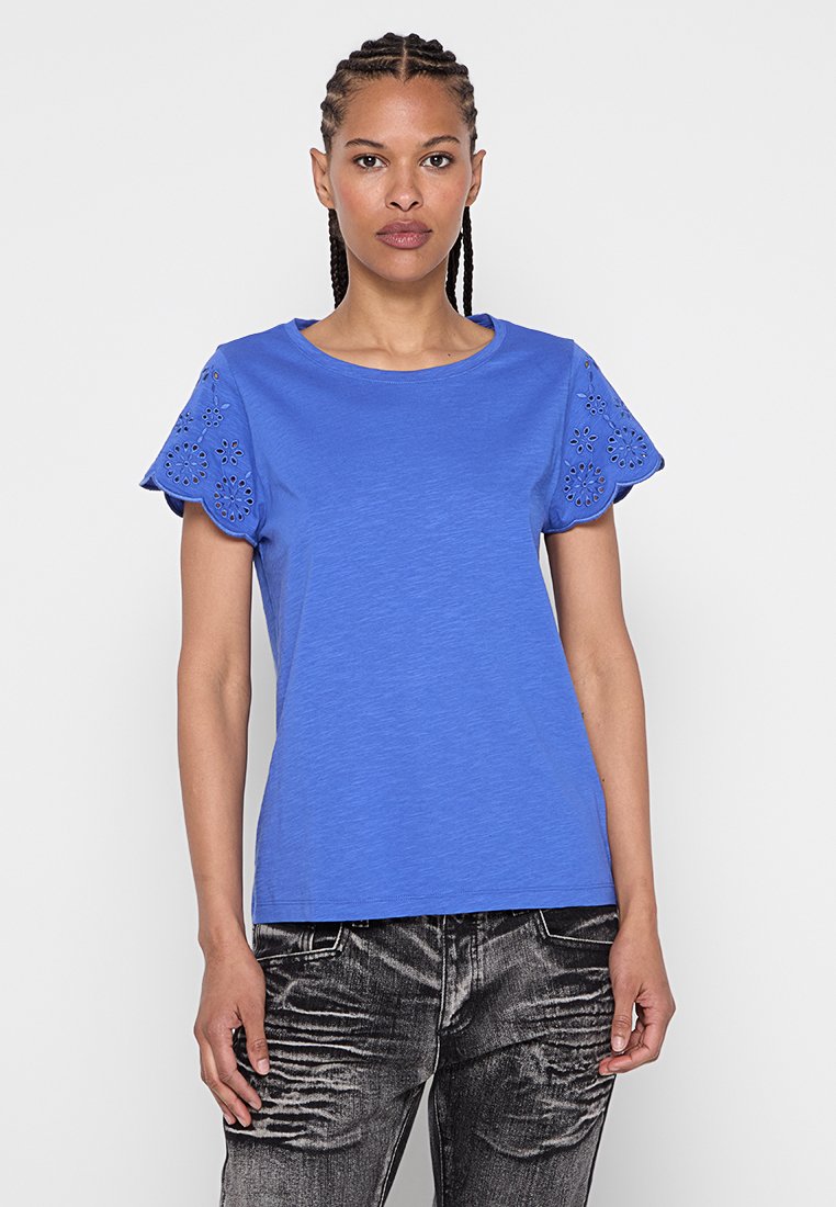 Blå bomull t-shirt med korta, dekorativa laserskurna ärmar. Slät textur, rundad hals och en figurnära passform.