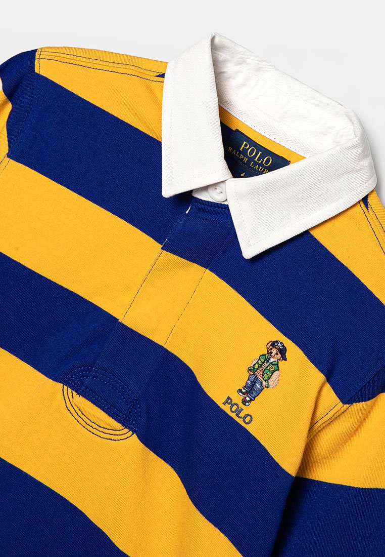 Blue and yellow striped rugby shirt featuring a white collar. Embroidered design of a character on the left chest area. Cotton material.