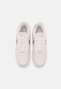 Witte leren sneakers met ton-sur-ton stiksels, perforaties op de neus en een textuur zijsteven logo. Veters en rubberen zool.