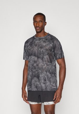 Zwarte T-shirt met patronen, versierd met complexe ontwerpen in het wit. Korte mouwen, ronde halslijn, gemaakt van lichtgewicht materiaal, geschikt voor sportieve kleding.