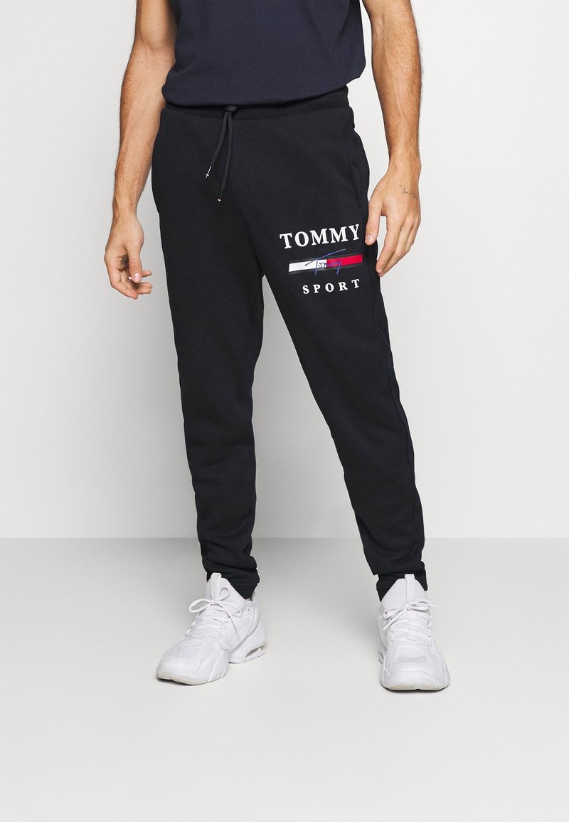 Schwarze Sweatpants aus Baumwolle mit einem weißen "TOMMY SPORT"-Logo, elastischem Bund mit Kordelzug und schmal zulaufenden Säumen.