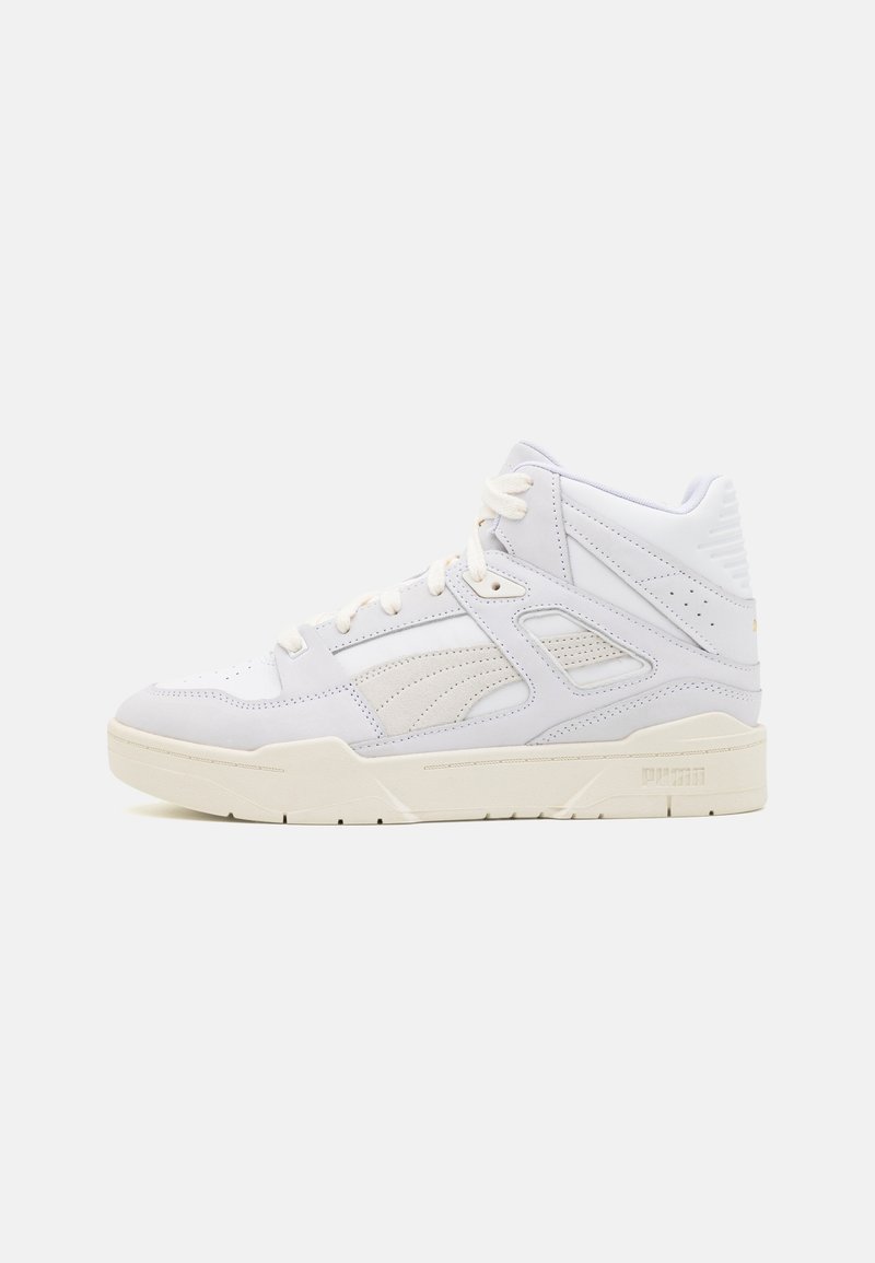 Baskets montantes blanches avec un mélange de cuir et de daim, présentant des accents perforés, des lacets et une semelle intermédiaire texturée. Logo sur le talon.