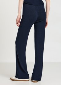 Marineblaue, weite Hose aus einem weichen, strukturierten Stoff mit einem elastischen Bund. Besitzt eine schlanke Form und minimalistische Details.