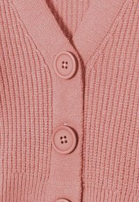 Rosa stickad cardigan med V-ringning, ribbad textur och fyra runda knappar med en subtil lyster.