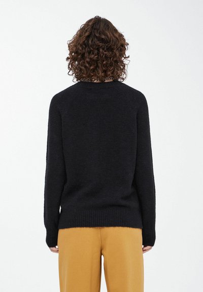 Zwarte trui met een ronde halslijn, lange mouwen en een ribbelrand. Gemaakt van zacht materiaal, met een gladde textuur en een minimalistisch design.