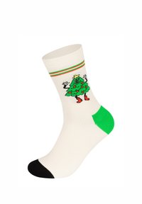 Bílé ponožky se zelenou patou a špičkou, na kterých je design vánočního stromečku s černými rukávy a červenými akcenty kolem kotníku.