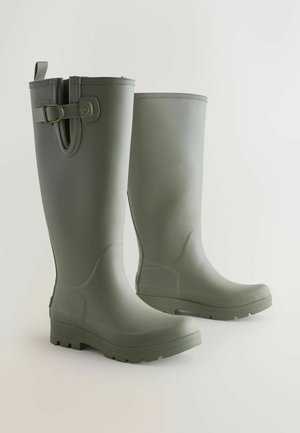 Grüne Gummiregenstiefel mit strukturierter Oberfläche, abgerundetem Zehenbereich und einer robusten Sohle. Mit einem seitlichen Riemenakzent und einem Zuglasche hinten.