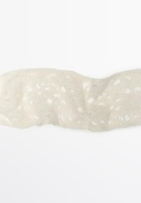 Tissu blanc texturé avec un design en dentelle, présentant des motifs en relief subtils et une apparence douce et translucide, de forme courbée.