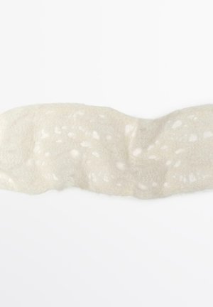 Tessuto bianco e testurizzato con un design simile al pizzo, caratterizzato da sottili motivi in rilievo e un aspetto morbido e trasparente, di forma curva.