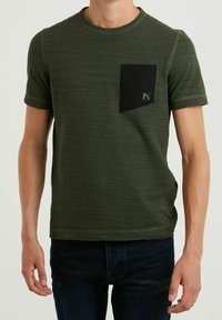 Camiseta de manga corta en verde oliva, hecha de una tela texturizada, con un bolsillo en el pecho negro que lleva un logo, cuello redondo y un diseño ajustado.