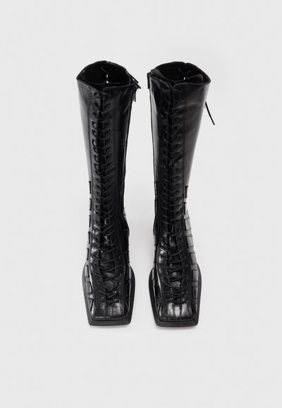 Black knee-high boots in smooth leather with a croc-embossed pattern. Features a full lace-up front and a square toe design.