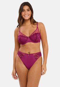 Ensemble de soutien-gorge et culotte bordeaux avec des accents en dentelle, un soutien-gorge avec armatures et un joli nœud délicat sur le devant du string.