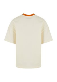 T-shirt en coton crème à manches courtes et col rond. Présente un accent orange à l'intérieur du col. Design simple et sans ornements.