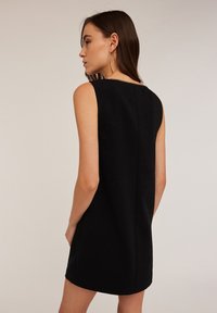 Schwarzes ärmelloses Kleid mit taillierter Passform, glatter Textur und einem dezenten Ausschnitt-Detail am Rücken. Minimalistischer Stil, knielang.