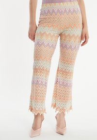 Kleurige spijkerbroek met zigzagpatroon in pastelkleuren van oranje, lavendel en munt, met een wijd been ontwerp en scalloped zoomdetails.