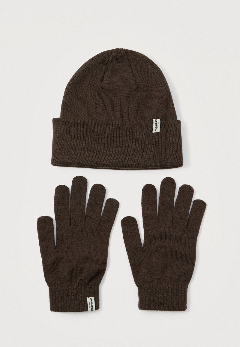 Dark brown knitted beanie and matching gloves laid flat on a light surface, both with a small white brand label attached.