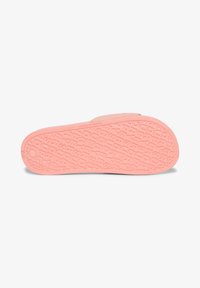 Semelle de sandale en caoutchouc pastel rose, avec un motif de logo texturé et en relief, présentant un bord lisse et arrondi ainsi qu'une construction légère.