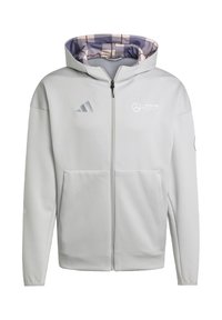 Helle graue Zip-Hoodie mit einem gemusterten lila und cremefarbenen Innenfutter. Verfügt über die Logos von adidas und Mercedes auf der Brust sowie eine Vordertasche.