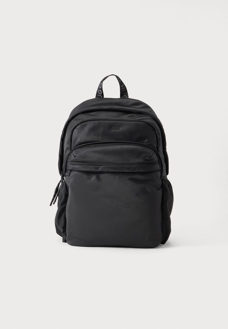 Sac à dos en nylon noir avec plusieurs compartiments zippés et une poignée supérieure marquée sur fond blanc uni.