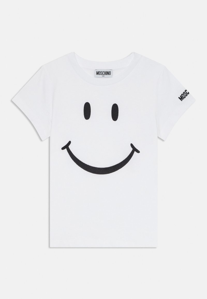 Bílé dětské tričko s krátkým rukávem s černým grafickým smajlíkem na přední straně a textem "Moschino" na štítku za krkem a na levém rukávu.