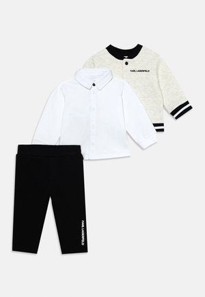 Set mit Kleinkindkleidung, bestehend aus einem weißen Hemd mit Knöpfen, schwarzen Hosen mit Logo und einer hellgrauen Langarmjacke mit schwarzem Besatz und Logo.
