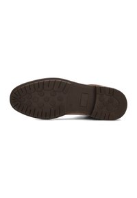 Suela de zapato de goma marrón con patrones de agarre texturizados y un diseño plano. Presenta una sección rectangular para el etiquetado de tallas.